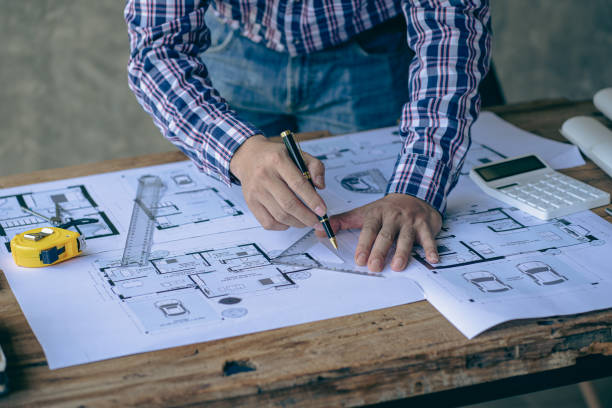 istock An engineer or architect working on a new project on a construction site. With blueprints and using a laptop draw a project design in the concept of an architectural engineer. 1417184293