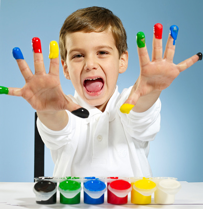 Kid playing with color paints