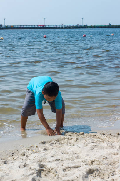 istock Kid playing on beach. Children play at sea 1417189994