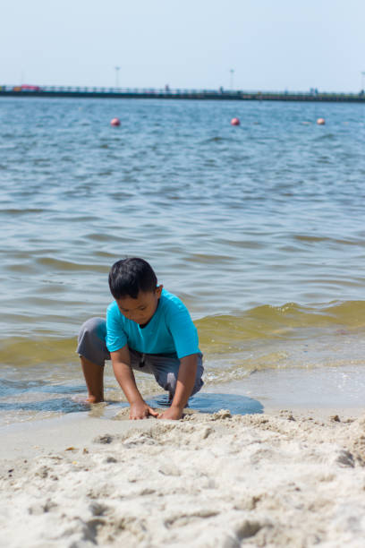 istock Kid playing on beach. Children play at sea 1417190003