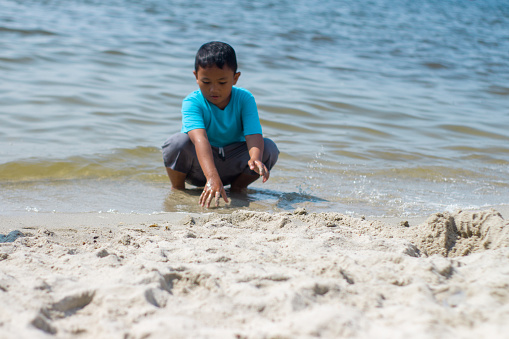 Kid playing on beach. Children play at sea