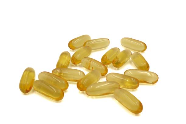 istock Medical: Golden Oval Fish Oil tablets in white background, close-up 1417193139