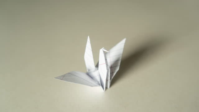 Folding Origami crane from crumpled paper