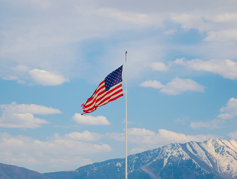 American flag in front of snowcapped mountains in Utah, USA