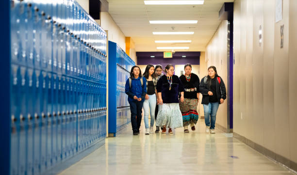 istock Female teacher giving advice to her students while walking thru a school corridor 1417198246