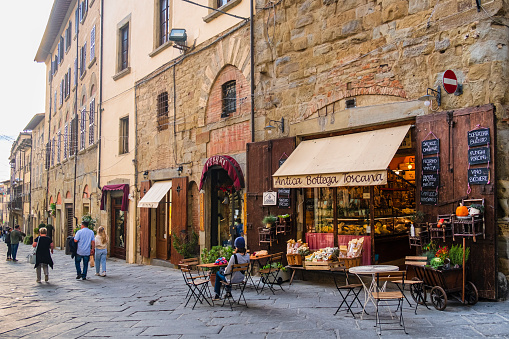 Tourists strolling in Corso Italia, for centuries the main street of Arezzo, mostly lined by historic buildings now hosting stores and bars