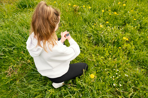 Teenage girl  looking at a smart watch while jogging in the park
