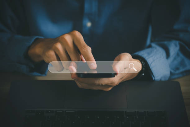 istock SEO Concept. Businessmen use smartphones with laptops. Search engine browsing Internet Data Information with a blank search bar. Search Engine SEO Networking. Optimization Marketing Ranking Traffic. 1417210385
