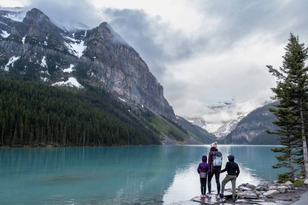 Family hiking around a pristine glacial lake in Banff National Park Family hiking around a pristine glacial lake in Banff National Park. Things to do in the National Parks of British Columbia. Hiking trails around Lake Louis travel9 stock pictures, royalty-free photos & images
