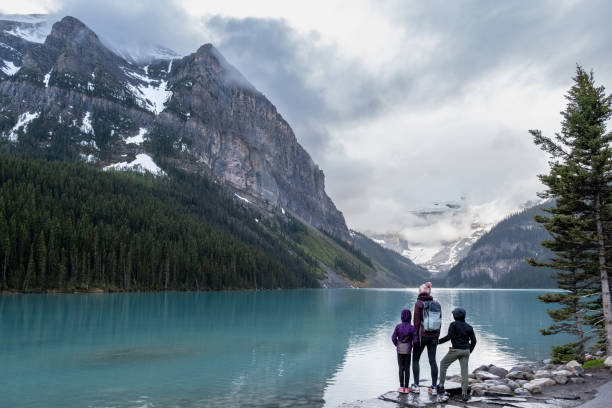 família caminhando em torno de um lago glacial intocado no parque nacional banff - lago louise - fotografias e filmes do acervo