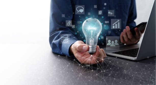 istock Network technology and business solution image.  Man holding lightbulb and smartphone. 1417215508