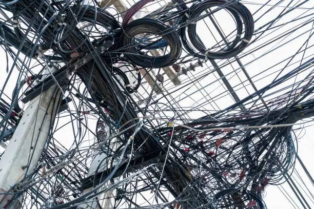 Photo of Tangled electrical wires on urban electric pole. Disorganized and messy to organization management concept. Closeup tangled electrical wires . Should take underground wire for beautiful landscape.