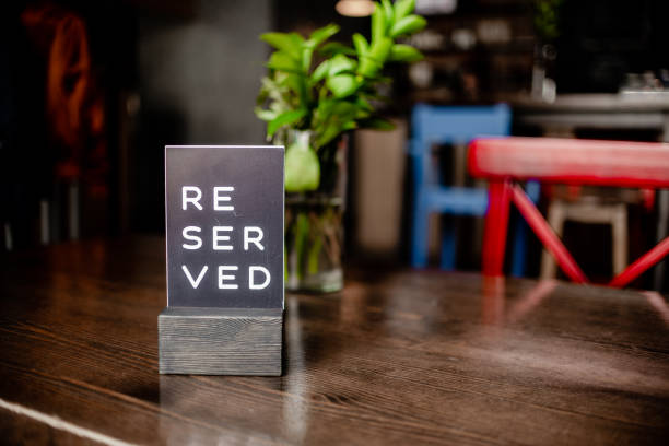 istock Reserved sign on a table in restaurant.Red chair and vase. Horizontal view several ojects. 1417219721