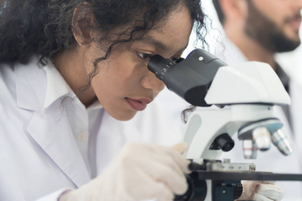 istock Close up woman scientist looking through microscope doing analysis for germs and bacteria of test sample in the laboratory. Female specialist working with biotechnology research with microscope 1417221416