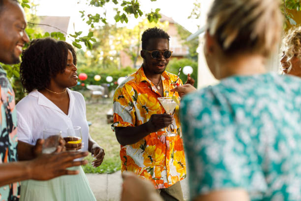 istock Group of friends dancing, laughing and adding drinking straws to their margaritas 1417226327