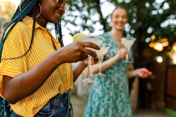 マルガリータカクテルでマティーニグラスを提供する2人の若い女性 - smart casual outdoors friendship happiness ストックフォトと画像