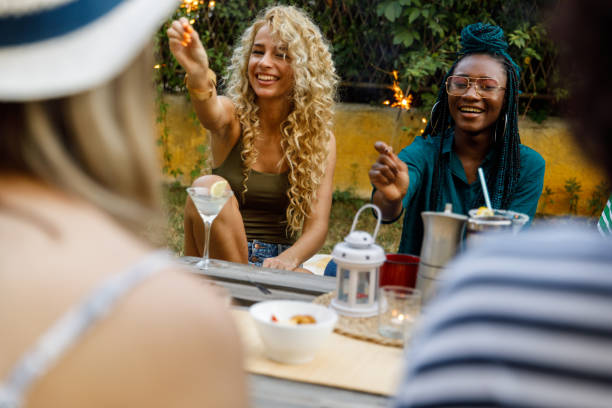 istock Two joyful young women smiling while holding sparklers during a picnic party 1417227631