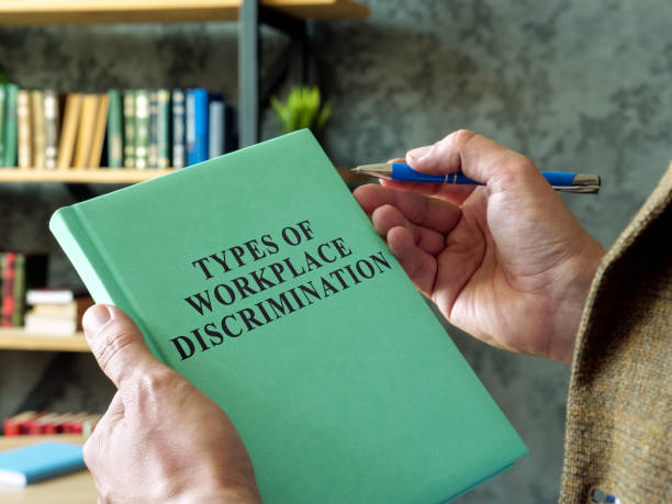 Manager holds book types of workplace discrimination. Manager holds book types of workplace discrimination. prejudice stock pictures, royalty-free photos & images