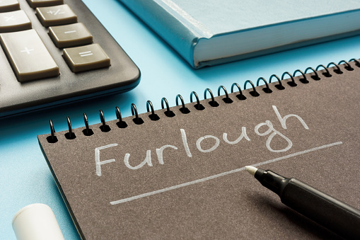 Written word Furlough on a notepad by marker.