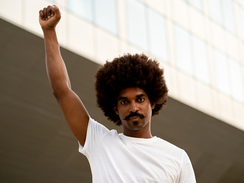 Black man with afro hair with fist raised