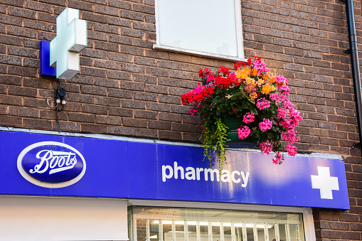 Holywell, Flintshire, UK: Aug 14, 2022: Shops and offices including Boots the High Street have floral hanging baskets decorating the buildings