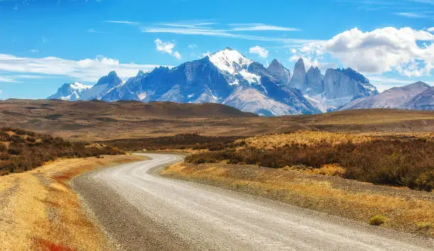 Gravel road in the Torres del Paine National Park. The mountains and rocks are covered with snow and ice