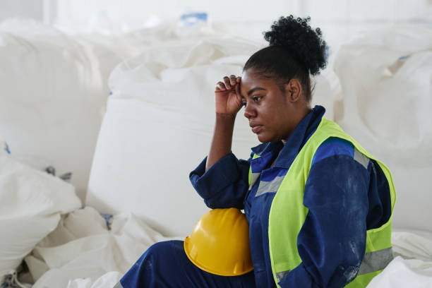 istock Young upset female engineer or worker of warehouse sitting by white sacks 1417270775