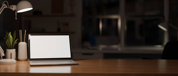 istock Workspace tabletop at night under the low light from table lamp with laptop computer mockup 1417281293