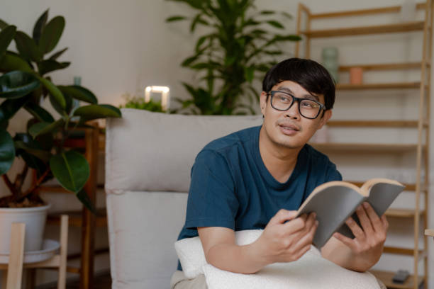 istock Asian adult sitting at home reading a book 1417283162