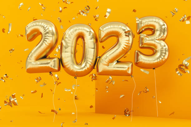 New Year Concept with Golden 2023 Balloons and Confetti on Yellow stock photo