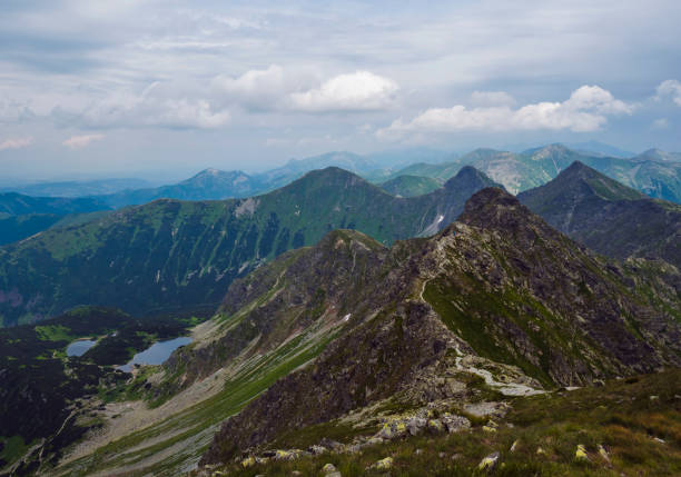 istock view from Banikov peak on Western Tatra mountains or Rohace panorama. Sharp green mountains - ostry rohac, placlive and volovec with hiking trail on ridge. Summer blue sky white clouds. 1417294881