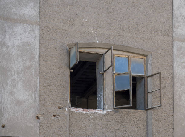 istock Aged abandoned empty retro vintage grunge house facade with open broken window, beige plaster, copy space 1417297244