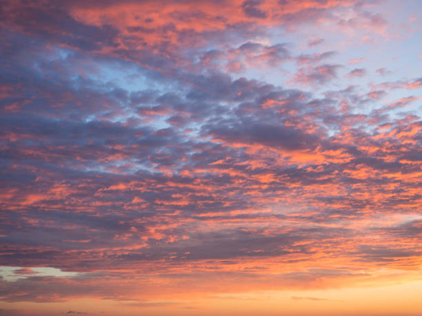 istock Texture, background, pattern. Sunset or dawn colored tropical clouds, red, pink, blue, orange and yellow pastel colors. Romantic sky at dusk with dynamic dramatic expressive clouds 1417300630