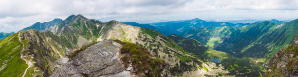 istock Panoramic view from Placlive peak on Western Tatra mountains or Rohace panorama. Sharp green mountains and lake rohacske pleso, ostry rohac, hruba kopa and volovec with hiking trail on ridge. Summer blue sky white clouds. 1417300812