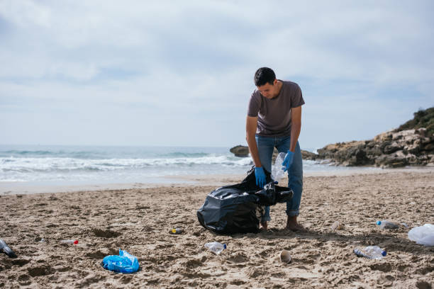 istock Volunteer man collecting trash on the beach. Ecology concept 1417303388