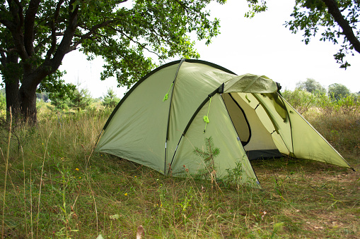 Outdoor camping with tent in summer forest. Tent in the summer forest. Rest at nature