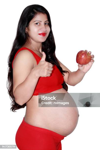 Pregnant Woman Holding An Apple Stock Photo - Download Image Now - Apple - Fruit, 20-24 Years, Abdomen