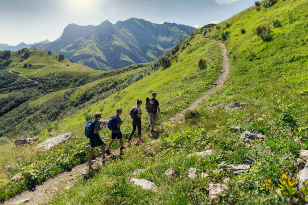 padre e hijos adolescentes haciendo senderismo en las altas montañas de austria (alpes, vorarlberg) - mountain austria european alps mountain peak fotografías e imágenes de stock