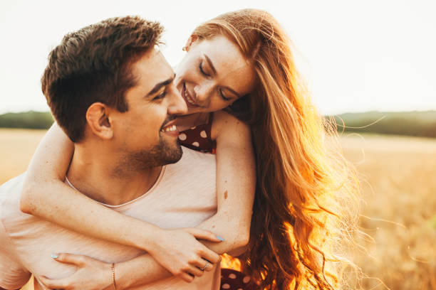istock Man giving his girlfriend a piggyback through a wheat field in summertime. Activity relationship. Love, dating. 1417310604
