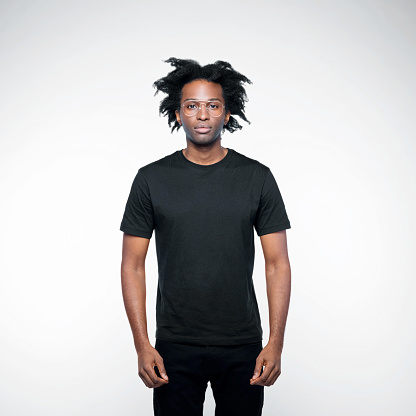 Confident afro american young man wearing black clothes, looking at camera. Studio shot on white background.