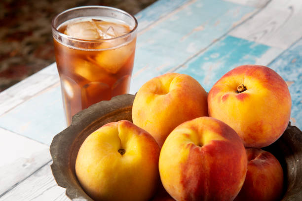 bevande fredde estive: tè ghiacciato di pesca fatto in casa con cubetti di ghiaccio e menta in bicchieri - peach nectarine wet drop foto e immagini stock