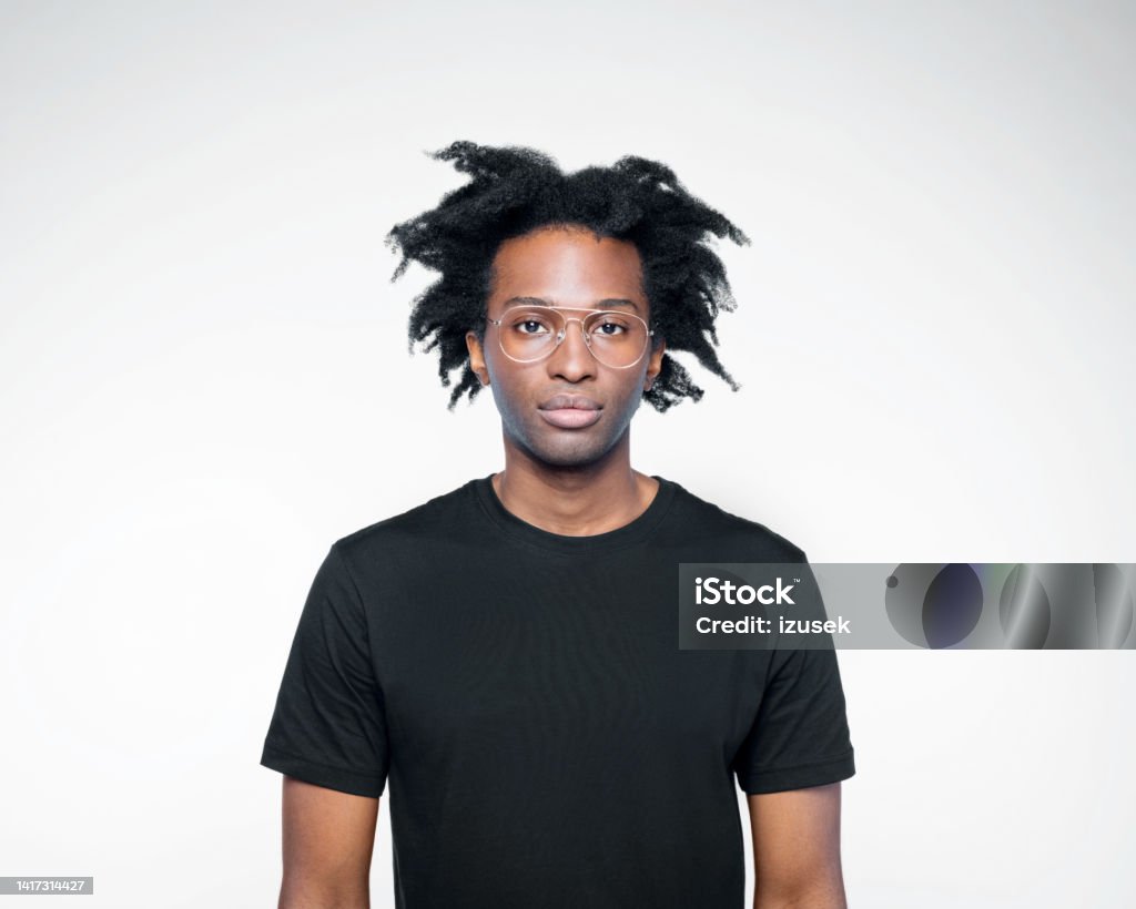 Portrait of man in black outfit Handsome afro american young man wearing black t-shirt and eyeglasses looking at camera. Studio shot on white background. Men Stock Photo