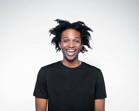 Excited afro american young man wearing black t-shirt, laughing at camera. Studio shot on white background.