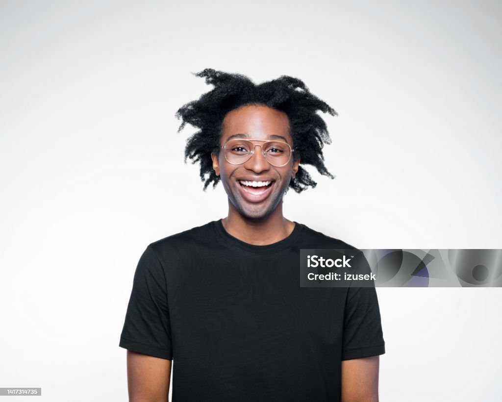 Potrait of happy man in black outfit Excited afro american young man wearing black t-shirt, laughing at camera. Studio shot on white background. African-American Ethnicity Stock Photo