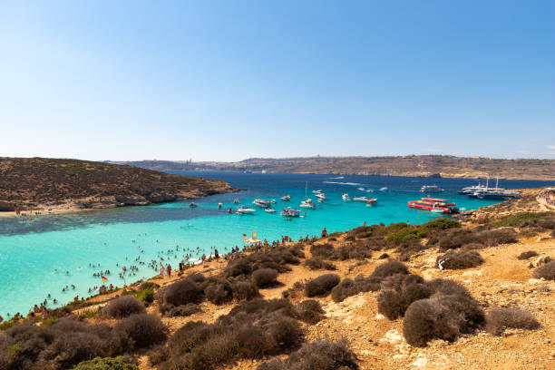 la laguna azul es una pequeña bahía popular para una excursión de un día con aguas poco profundas y de color azul en la costa oeste de la isla de comino. - gozo malta natural arch natural phenomenon fotografías e imágenes de stock