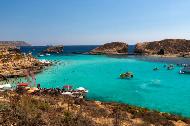 la laguna azul es una pequeña bahía popular para una excursión de un día con aguas poco profundas y de color azul en la costa oeste de la isla de comino. - gozo malta natural arch natural phenomenon fotografías e imágenes de stock