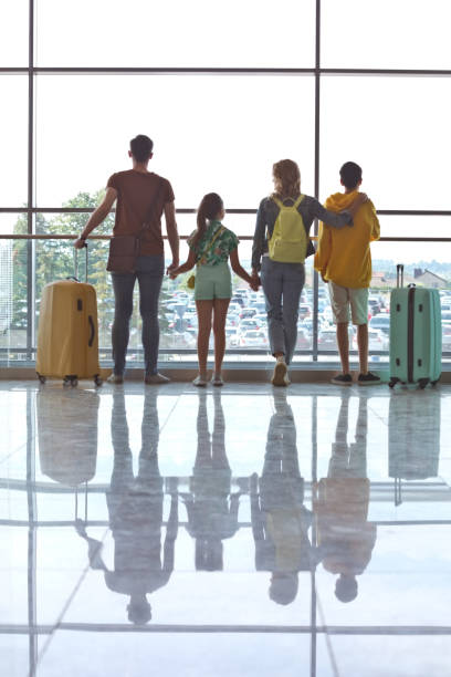 istock Family looking through airport window 1417315242