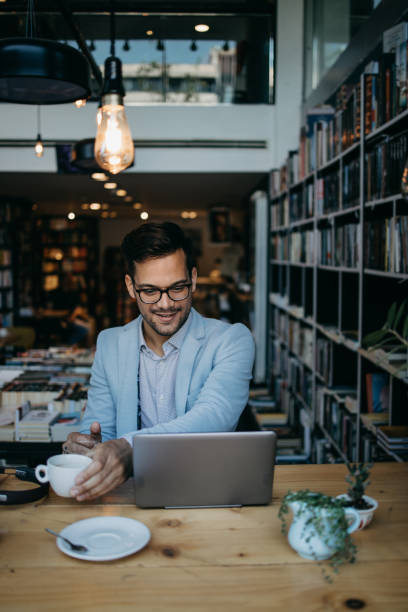 istock Attractive man using laptop in bookstore 1417315417