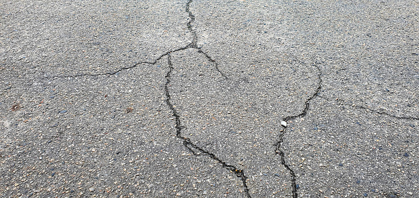 Cracks in the asphalt. An old road with cracked asphalt. The road needs repair