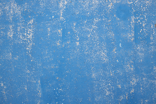 Abstract background is blue. Concrete wall with cracked and rough surface.